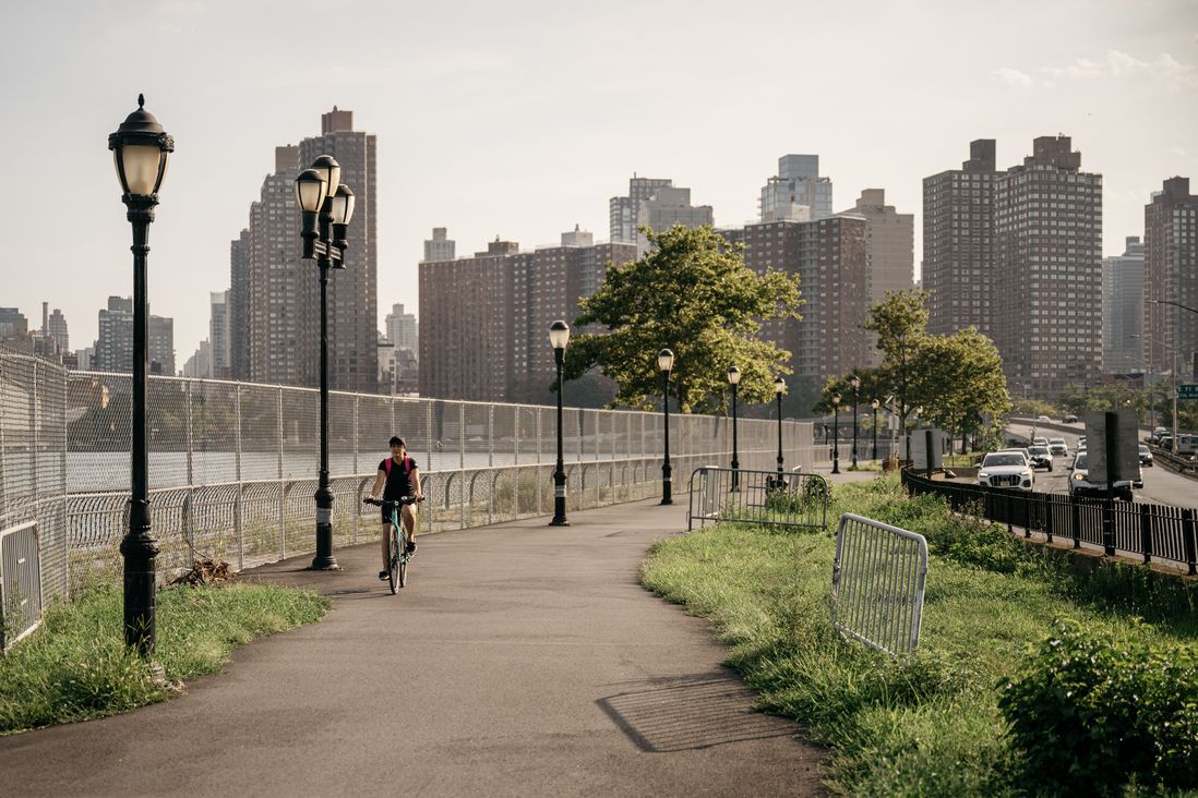 A cyclist bikes past a fenced-off portion of the East River Esplanade. The waterfront was damaged during Hurricane Sandy. The city has made some repairs since then, but advocates are calling for the waterfront to be elevated to protect against future storms.